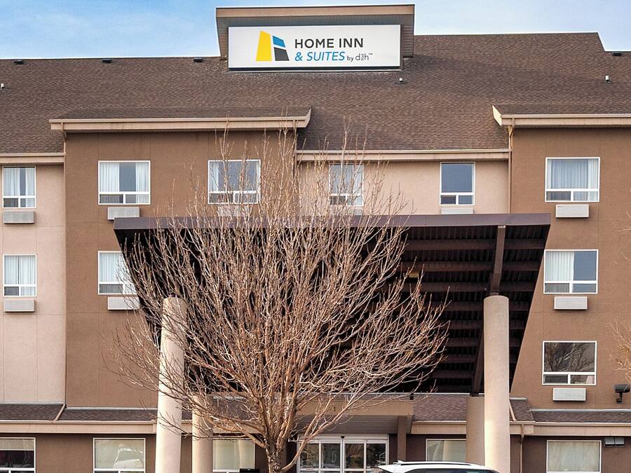 Um edifício com uma placa que diz 'Home Inn & Suites by Dhl'.