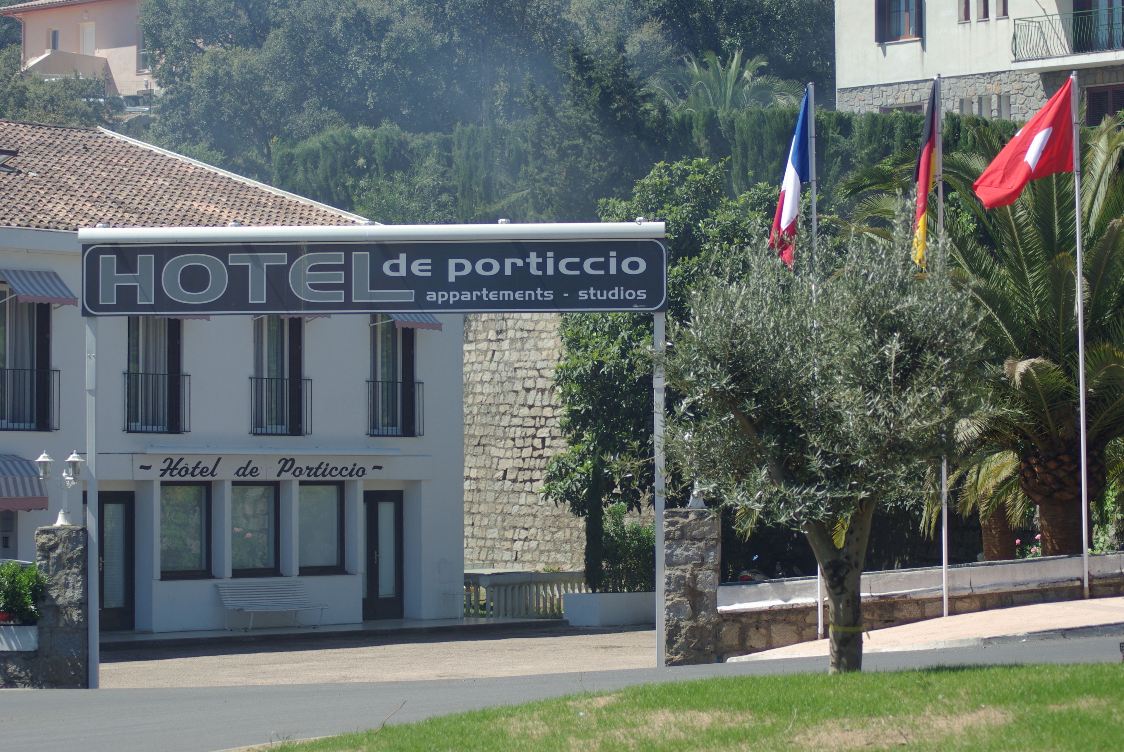 A hotel sign with "HOTEL de porticio" and flags.