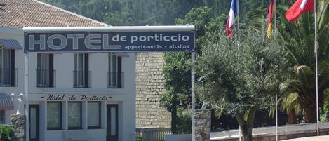 Un letrero de hotel que dice 'HOTEL de porticio' y banderas.