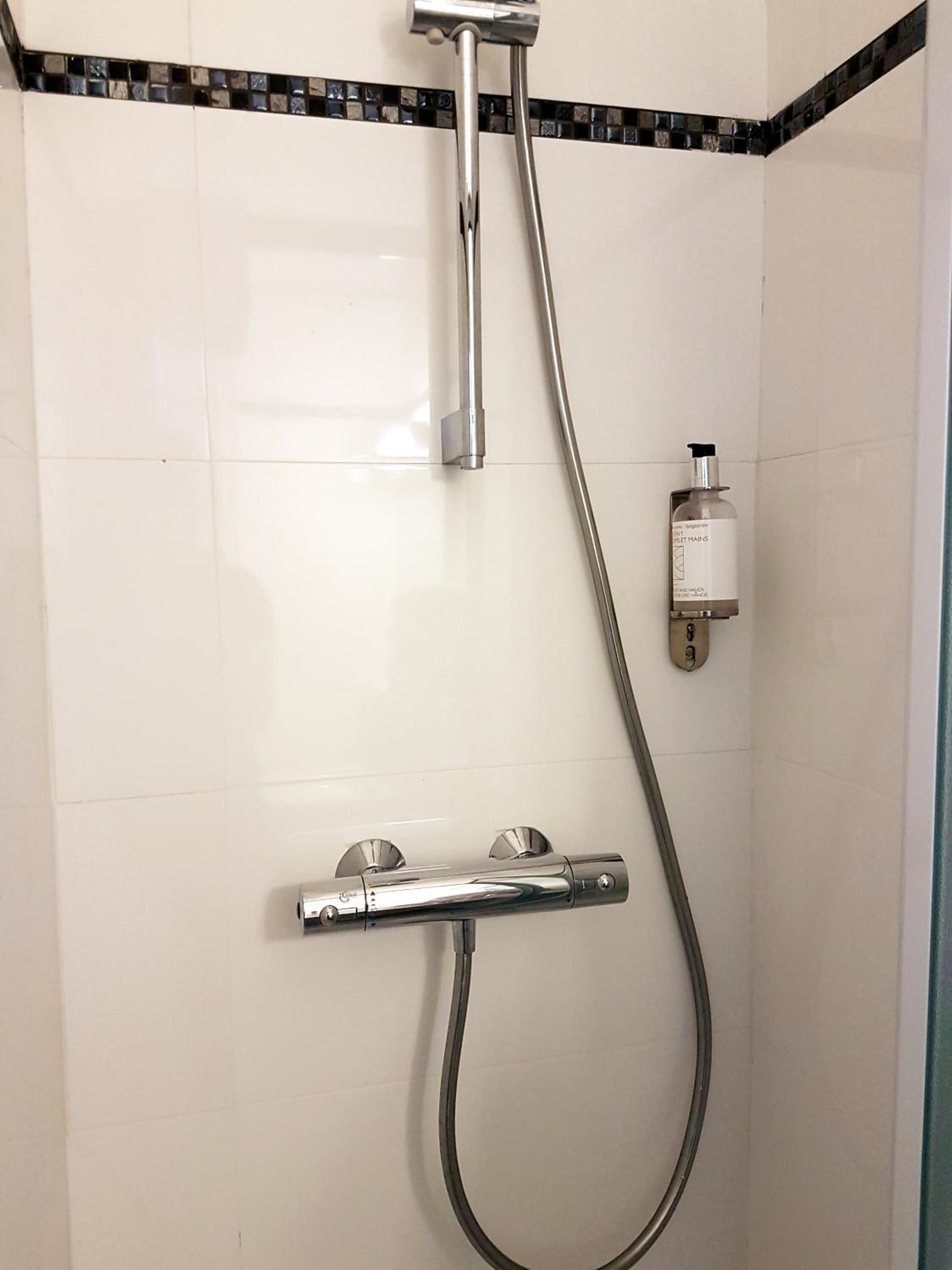 Ducha con cabezal de ducha de mano y grifo empotrado.