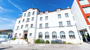A white building with multiple windows and a red roof. - Hotel Evenia Monte Real (Leiria)