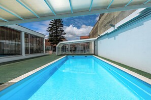 Una piscina cubierta, una piscina al aire libre, tumbonas
