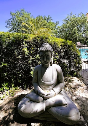 A seated statue in a garden setting. - La Résidence du Moulin (Tourrettes-sur-Loup)