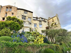 A stone building with multiple windows and balconies, surrounded by lush greenery and cacti. - La Résidence du Moulin (Tourrettes-sur-Loup)