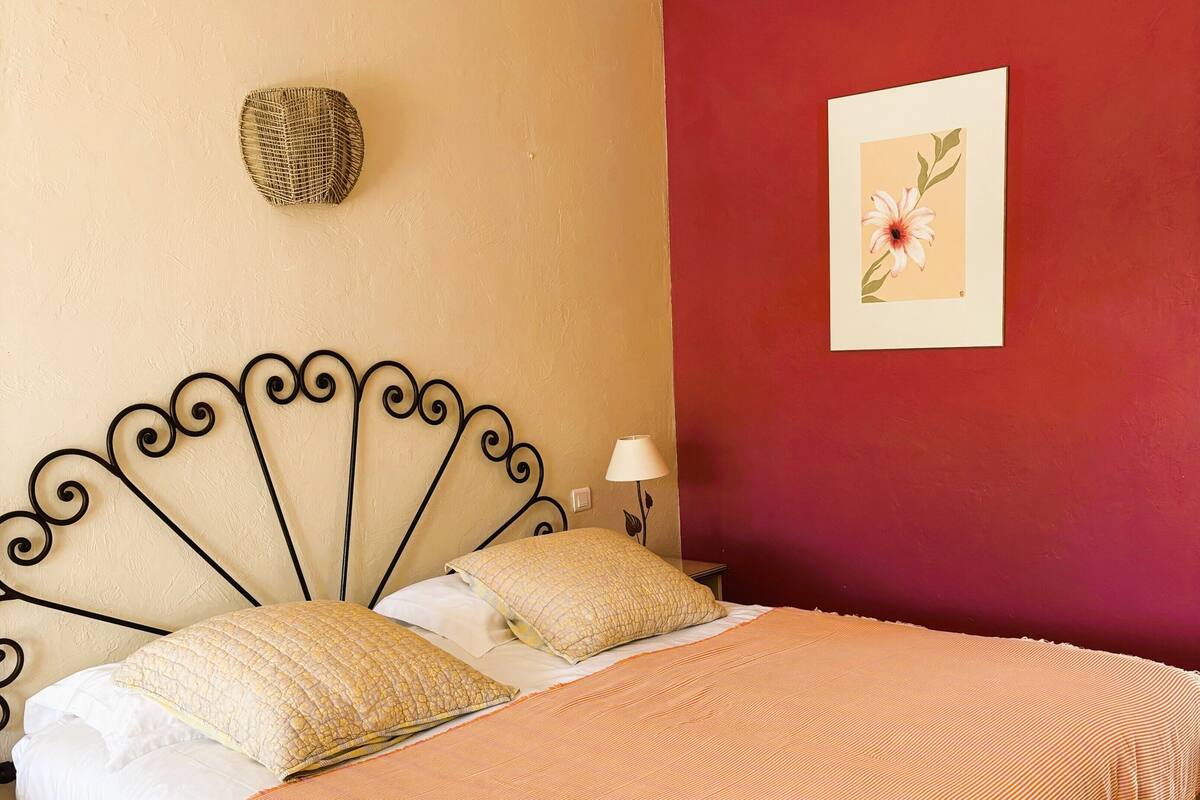 A bed with a headboard, pillows, and a blanket.