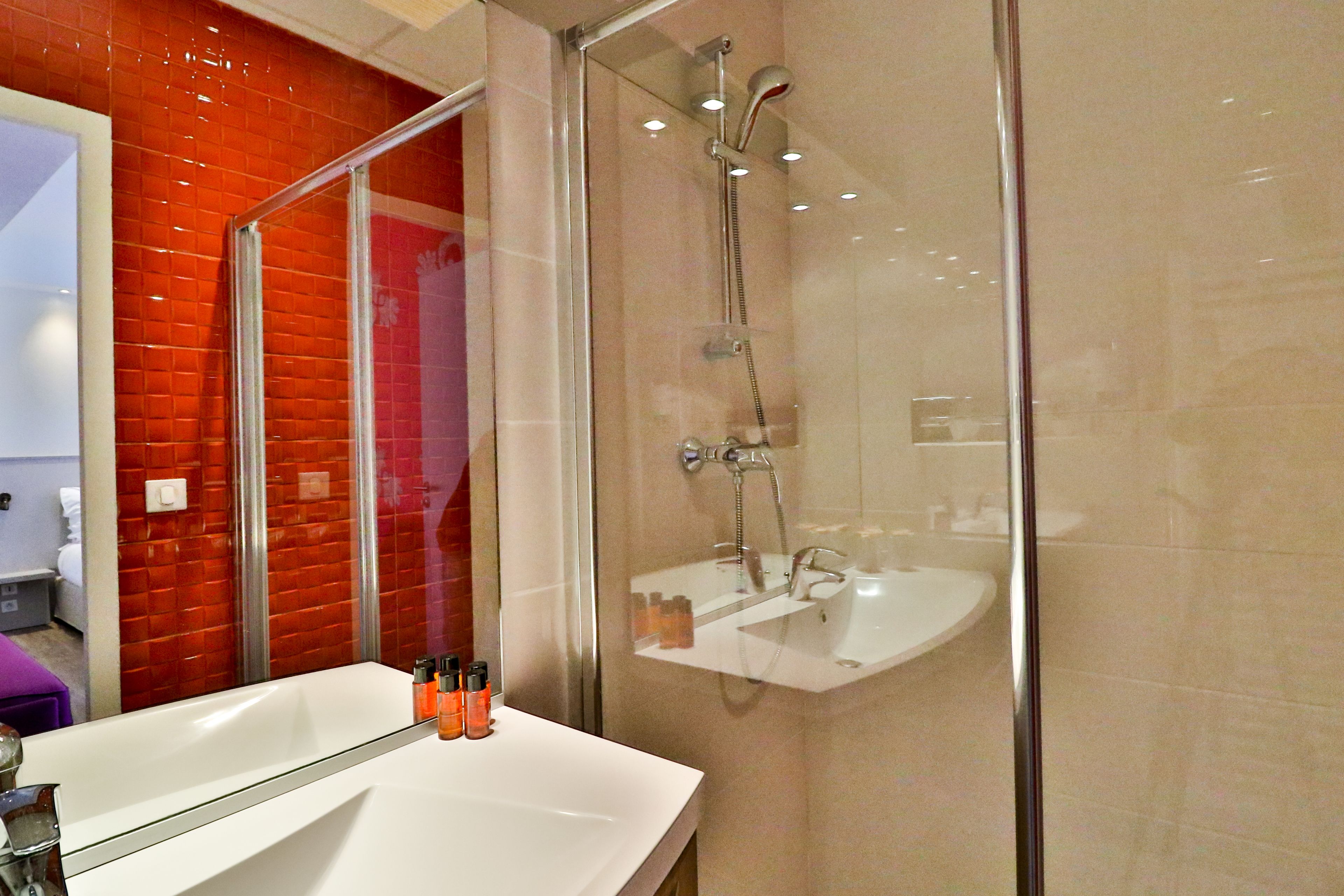 Un baño con ducha de vidrio, un lavabo blanco y un espejo.