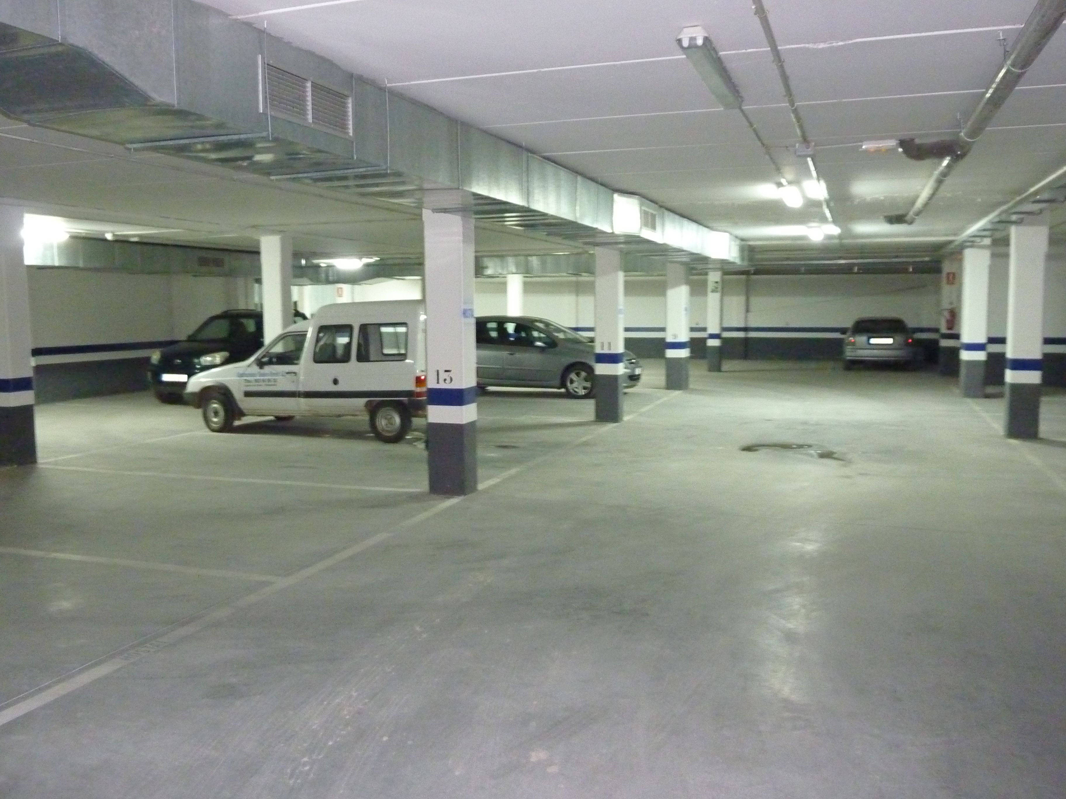 Un estacionamiento con varios niveles y varios coches aparcados.