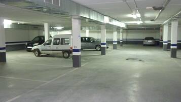 Un estacionamiento con varios niveles y varios coches aparcados.