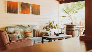 A cozy living room with a sofa, a coffee table, and a plant.