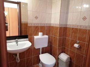 A bathroom with a sink, toilet, and a trash bin. - Hotel Ferihegy (Budapest)