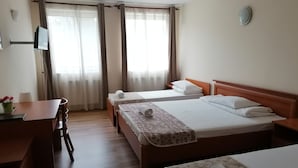 Une chambre d’hôtel avec deux lits, un bureau et une chaise.