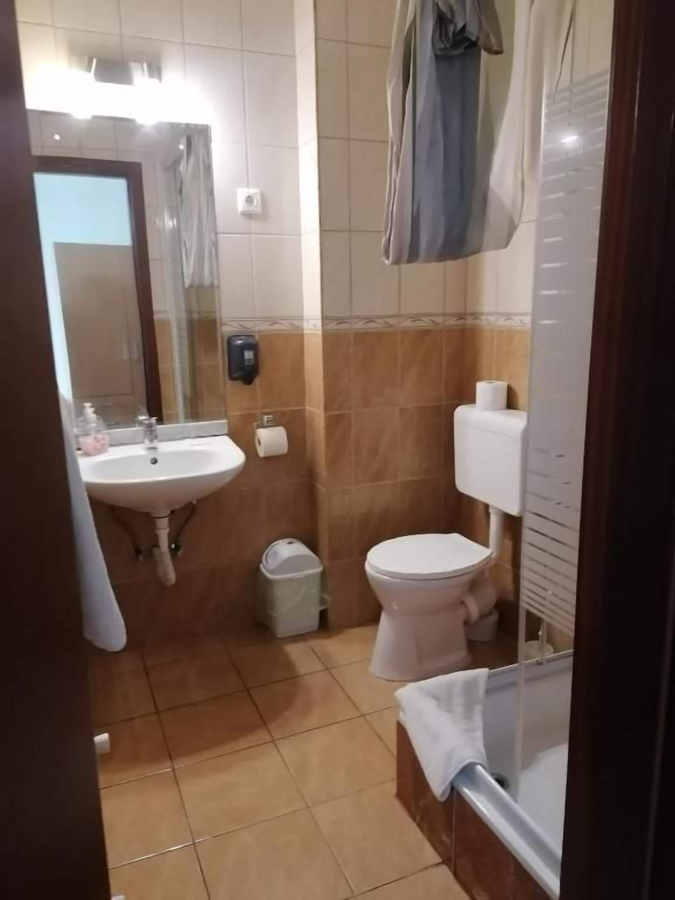 Un baño con lavamanos, inodoro y espejo.