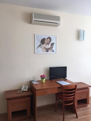 A room with a desk, chair, phone, and a framed picture on the wall. - Hotel Ferihegy (Budapest)