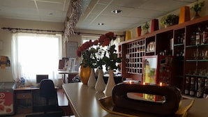 L’intérieur d’un restaurant, avec un comptoir, un espace pour les clients et un tableau affichant le menu.