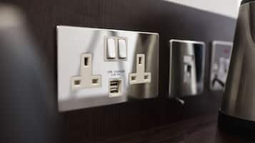 A wall-mounted electrical outlet with USB and standard plug sockets, and a power outlet with a plug.