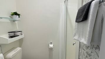 A compact bathroom with a toilet, sink, and shower.