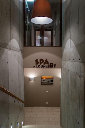 A staircase leading to a spa lounge with a sign reading "SPA LOUNGE".