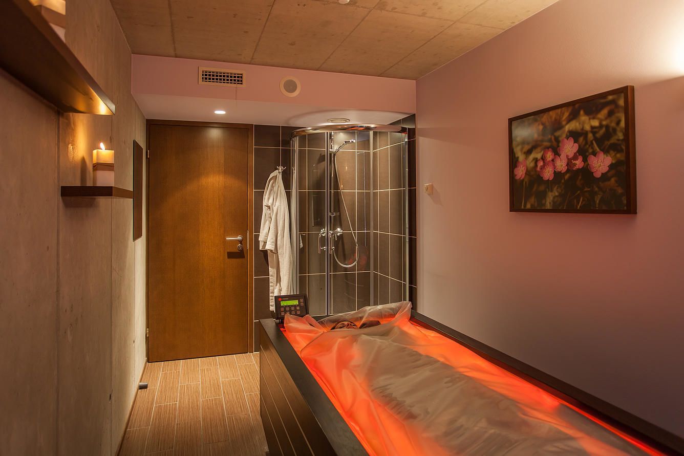 Ein modernes Badezimmer mit Duschabtrennung aus Glas, Fußbodenheizung und einem Bild an der Wand.