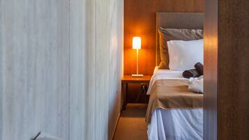 A hotel room with a bed, bedside lamp, and a telephone on the nightstand.