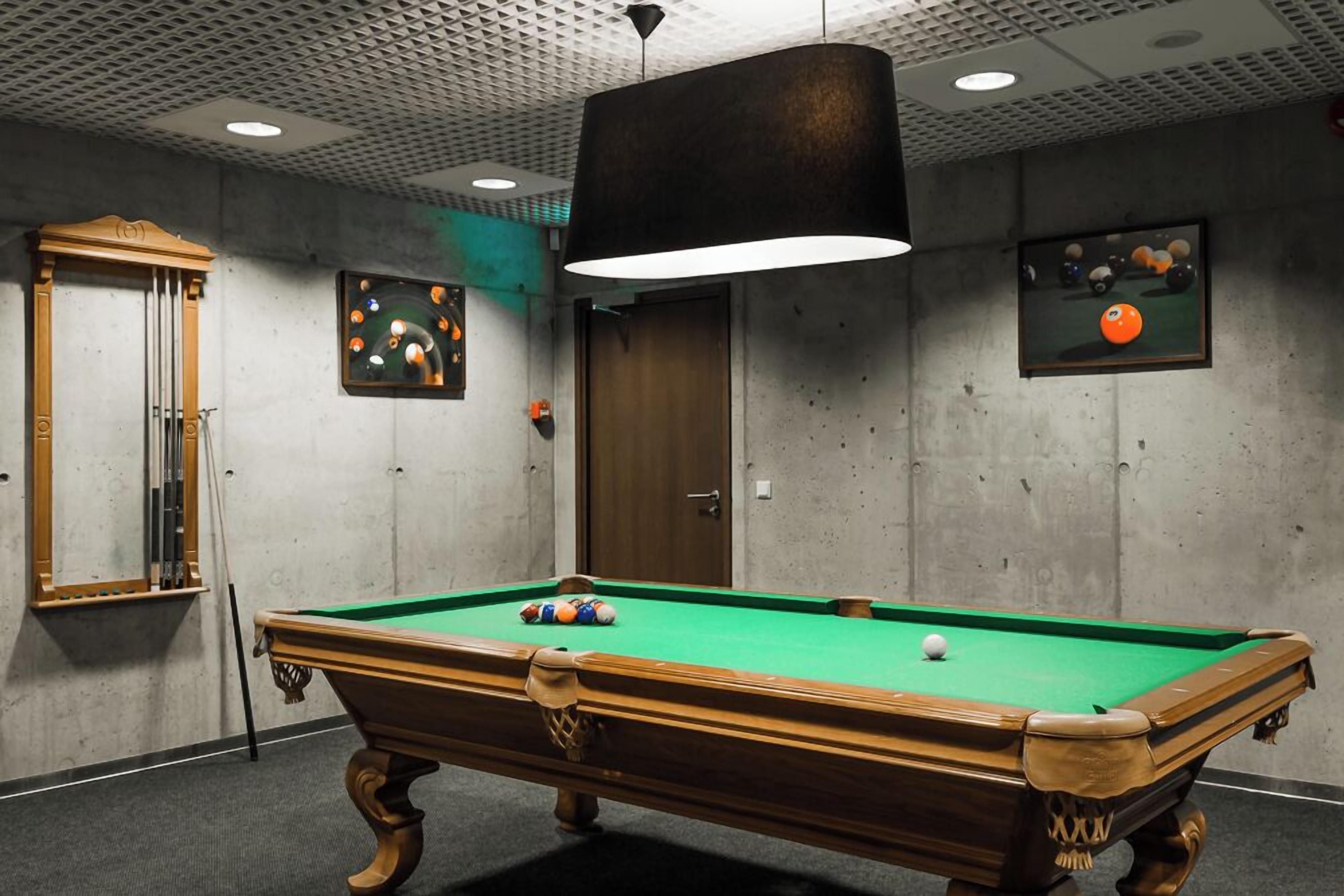 A pool table with balls, a wooden cabinet, and a door.