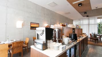 Uma cozinha moderna com espaço para café, área de jantar e janelas amplas.