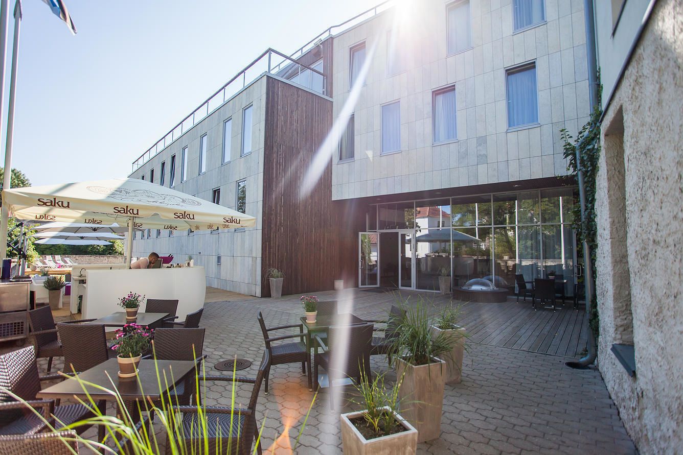 Un patio al aire libre con asientos, una barra y la entrada a un edificio.