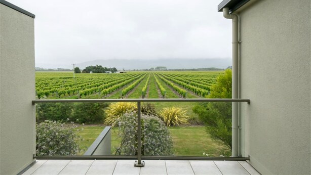 A balcony with a view of a vineyard. - Vintner's Retreat (Rapaura)
