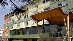 A multi-story building with a unique wooden structure on the ground floor, large windows, and a staircase leading to the entrance. - Ethic Etapes Dijon (Dijon)