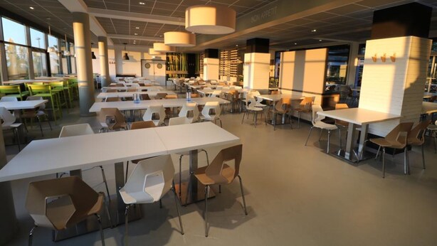A spacious dining area with multiple tables and chairs, large windows, and a modern ceiling design. - Ethic Etapes Dijon (Dijon)