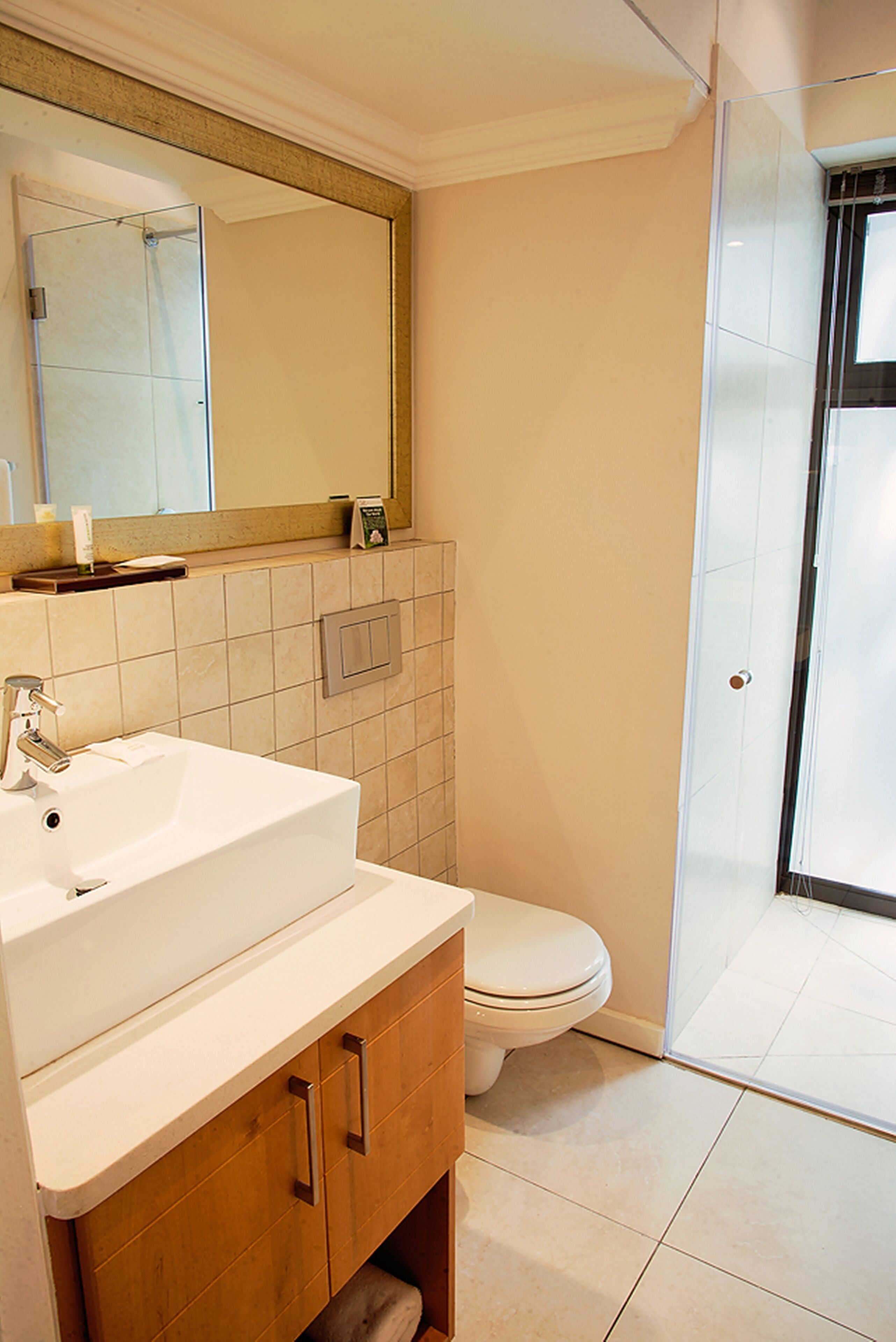 A bathroom with a white sink, mirror, and toilet.