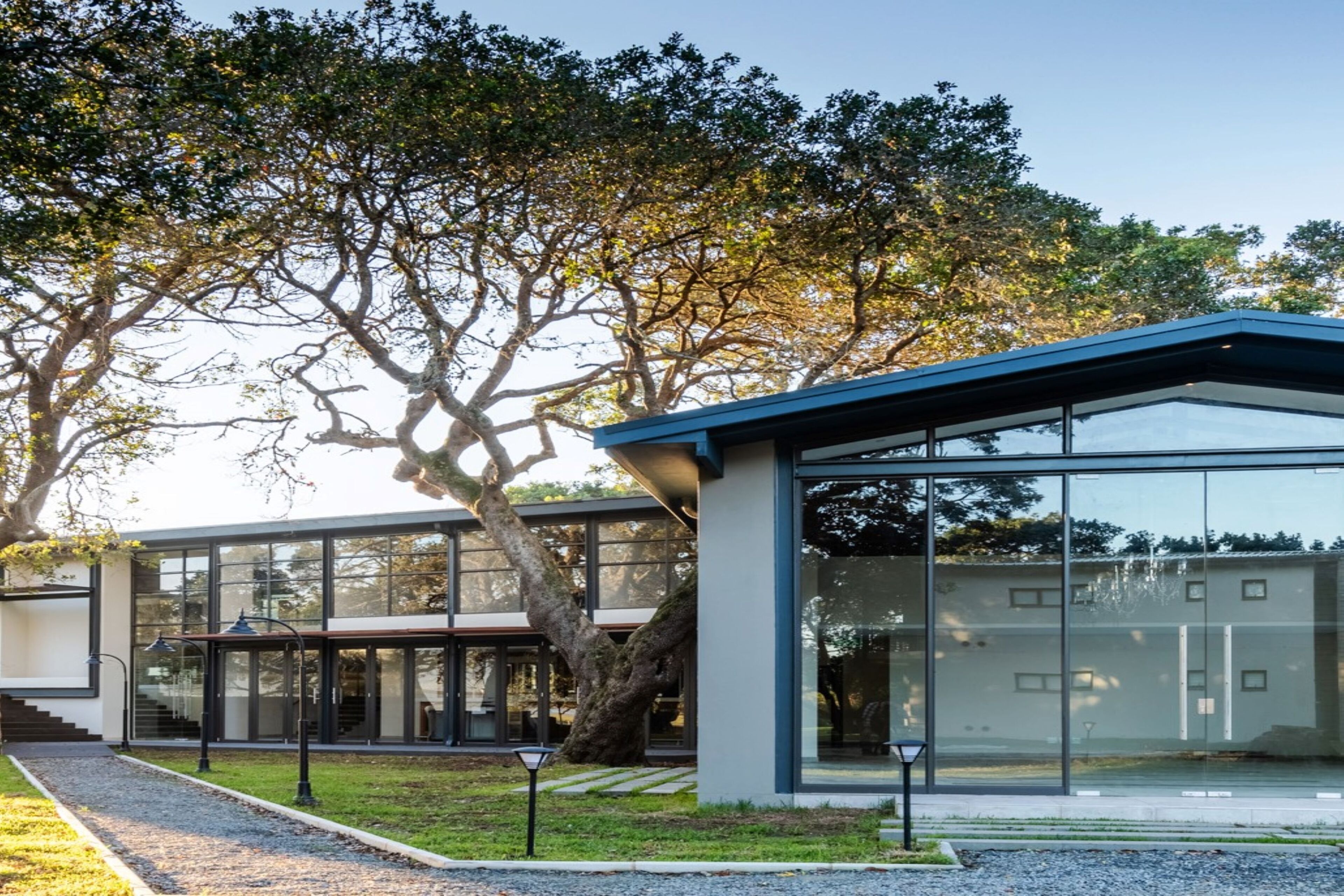 Un edificio moderno con amplios ventanales y un espacio exterior cubierto.