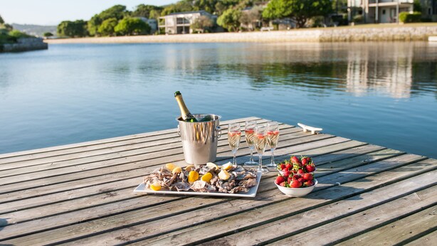 A wooden pier with a seafood platter, champagne, and glasses of wine. - Premier Resort The Moorings, Knysna (Knysna)