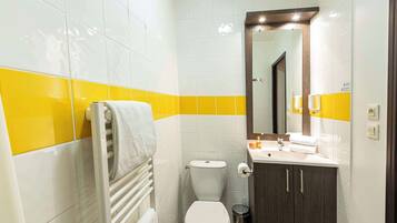 Een badkamer met toilet, wastafel en spiegel.