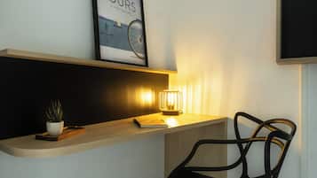 A desk with a potted plant, a notebook, and a framed picture of a bicycle tour.