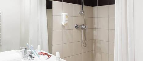 A bathroom with a shower, a sink, and a mirror.