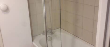 A bathroom with a glass-enclosed shower, a white toilet, and a bathtub.