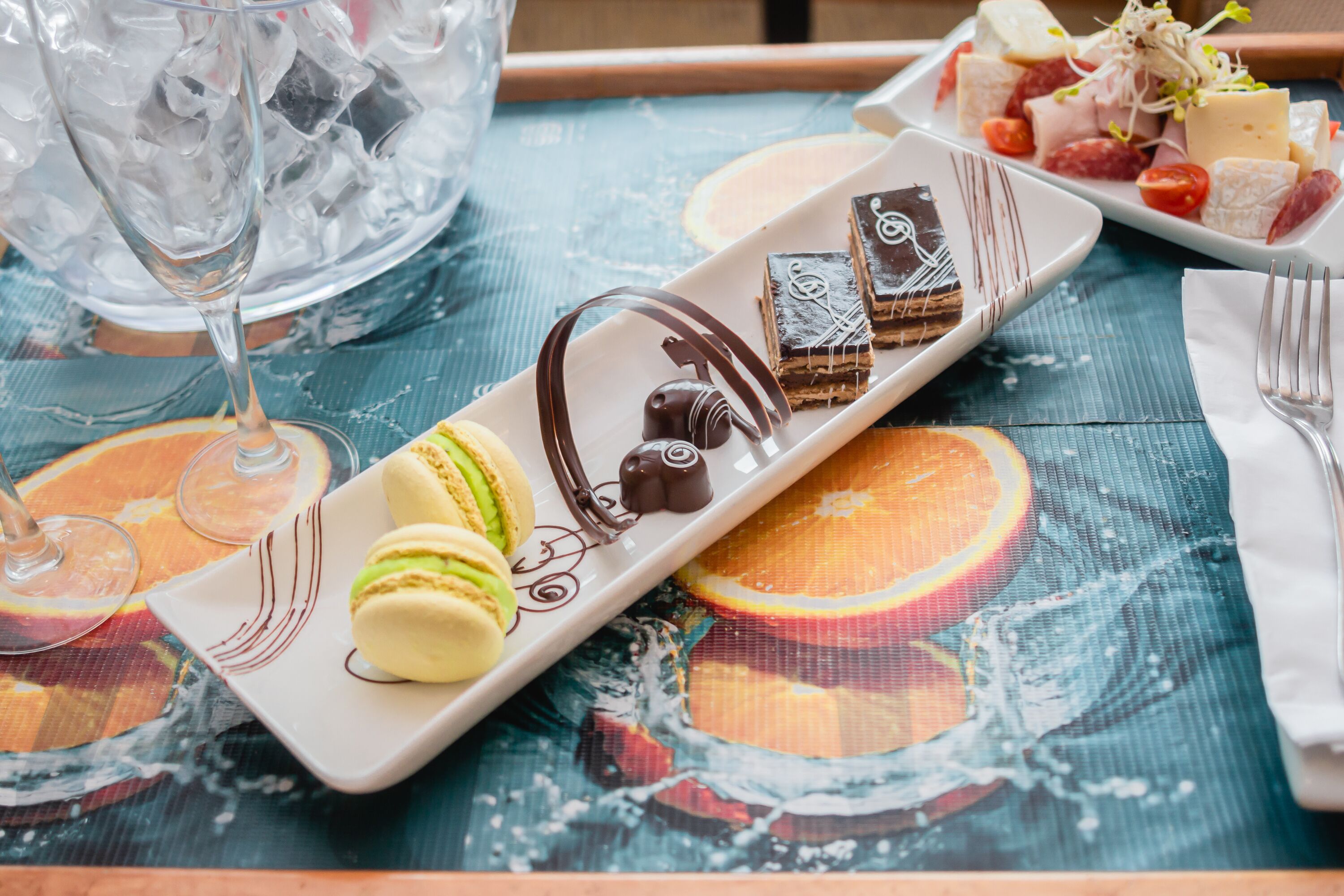Ein Tisch mit verschiedenen Desserts, darunter Macarons, Schokolade und Käse.