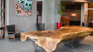 A modern lobby with a large wooden table, comfortable seating, and a large painting on the wall. - Sonesta Hotel Osorno (Osorno)