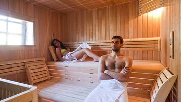 A sauna with wooden benches and a bench with a towel.