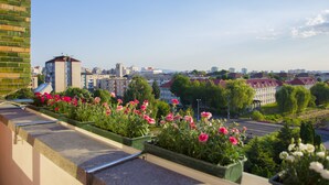 Un balcón con plantas en macetas y vistas de un paisaje urbano.