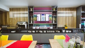 Una cuina moderna amb una illa central, un salvassecs de colors i una varietat d'estris i utensilis de cuina.