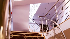 A staircase with a metal railing and patterned steps leading to a landing. - Hotel Apollonia (Brasov)