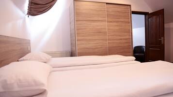 A neatly made bed with white linens in a hotel room.