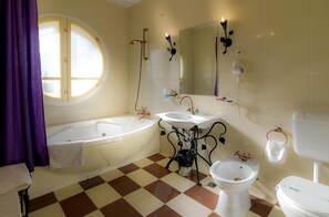 A bathroom with a bathtub, two sinks, a bidet, and a toilet. - Elite Hotel Oradea (Oradea)
