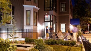 A multi-story building with a well-maintained lawn and a gated entrance. - Hotel Veritas (Cambridge)
