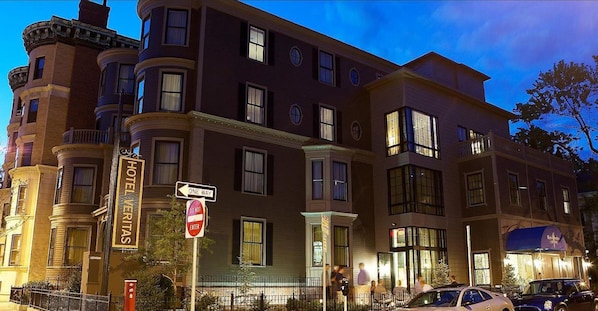 A multi-story building with a "HOTEL" sign, a "ONE WAY" street sign, and a "DO NOT ENTER" sign.