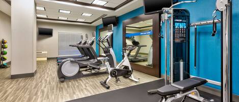 A gym with treadmills, an elliptical, and a weight bench.