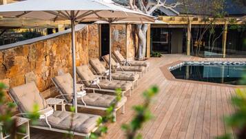 A poolside area with lounge chairs and umbrellas.
