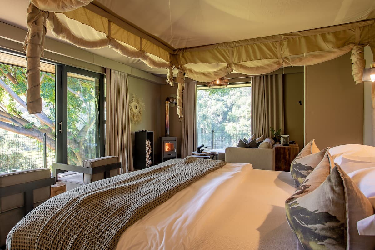Un dormitorio con una cama grande, un escritorio y vistas a árboles a través de la ventana.