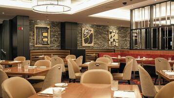 A restaurant with booths and tables, modern decor, and artwork on the walls.